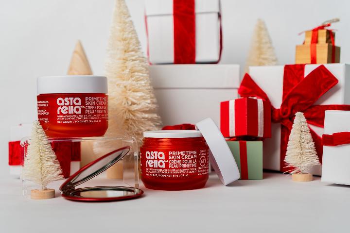 Astarella Primetime Skin Cream containers displayed in a white holiday theme