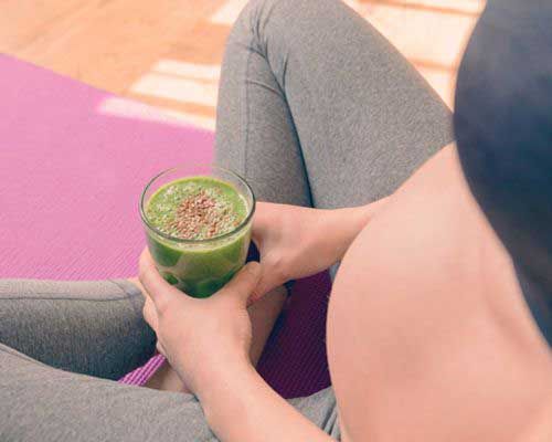 Pregnant woman holding Chlorella mixed into a drink - Sun Chlorella USA