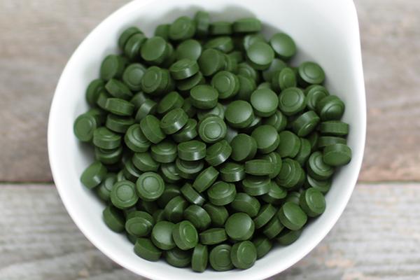 Sun Chlorella 200mg tablets in a white ceramic bowl