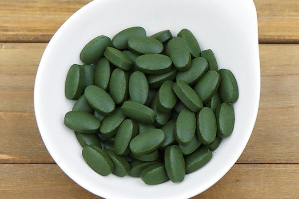 Sun Chlorella 500mg tablets in a white ceramic bowl