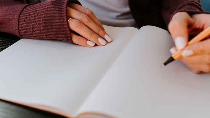 A picture of someone writing on a notepad