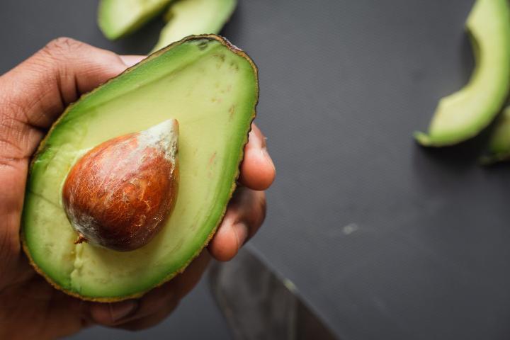 Person holding avocado