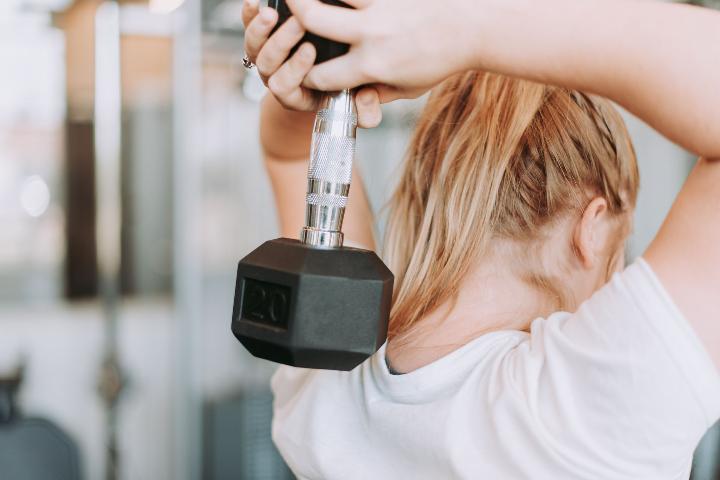 Woman holding a dumbbell behind her head
