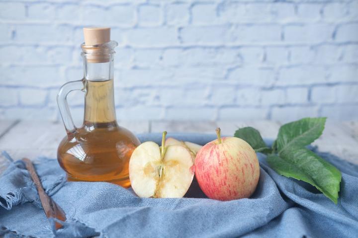 Apple Cider Vinegar alongside some split apples