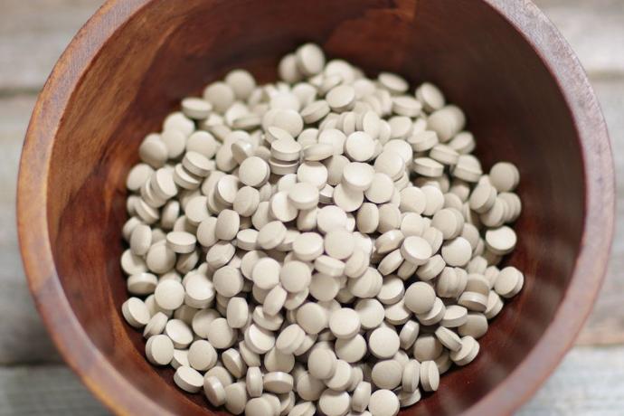 Sun Eleuthero tablets in a wooden bowl