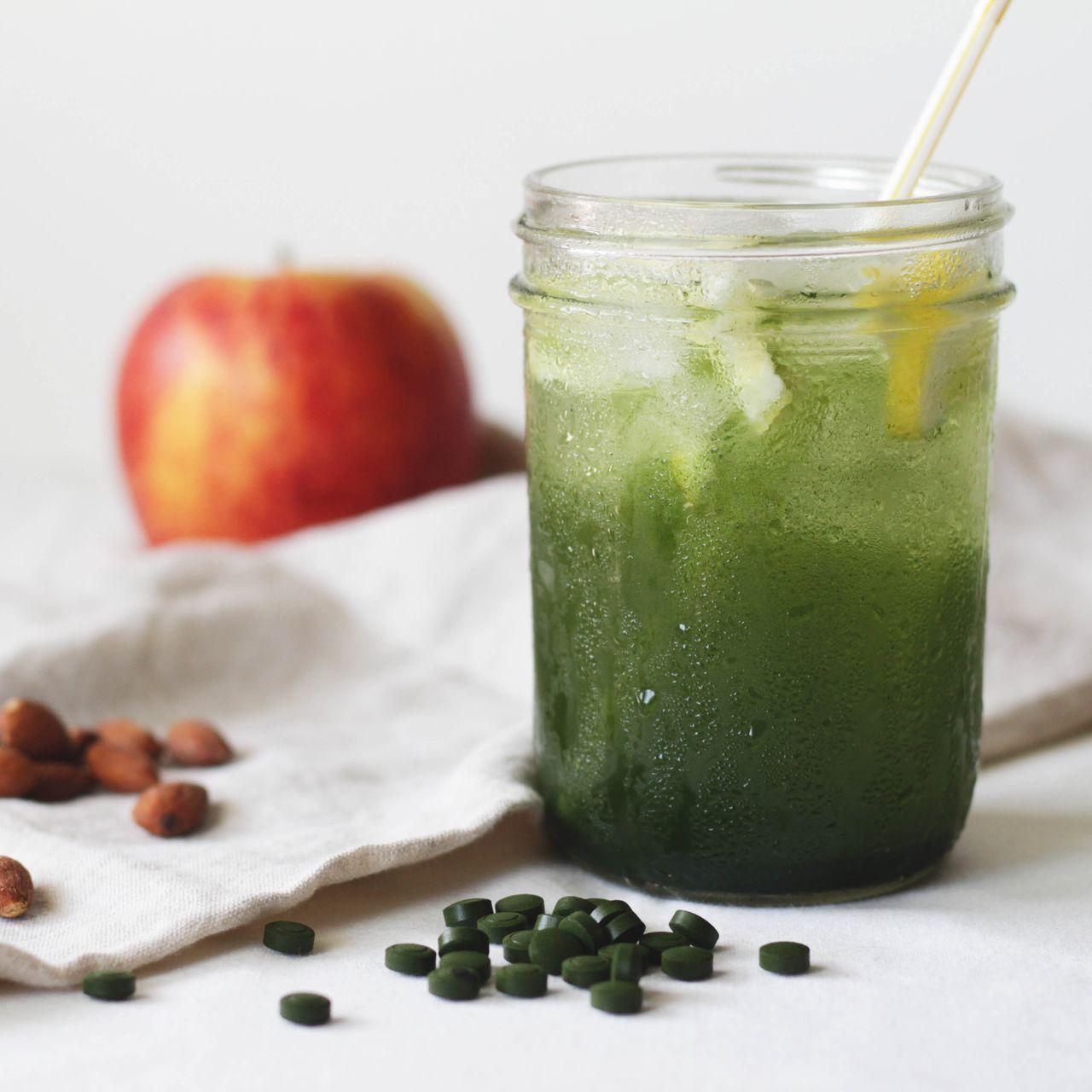 Chlorella Beverage with fruit and nuts beside it