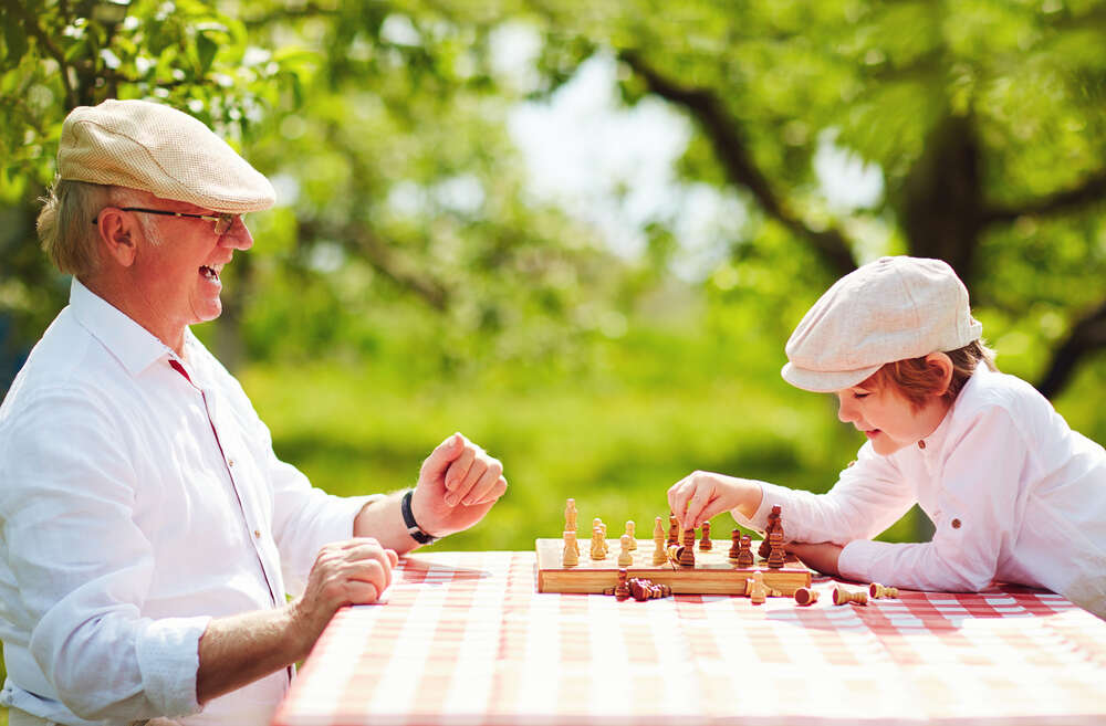 Grandpa and grandson playing chess 