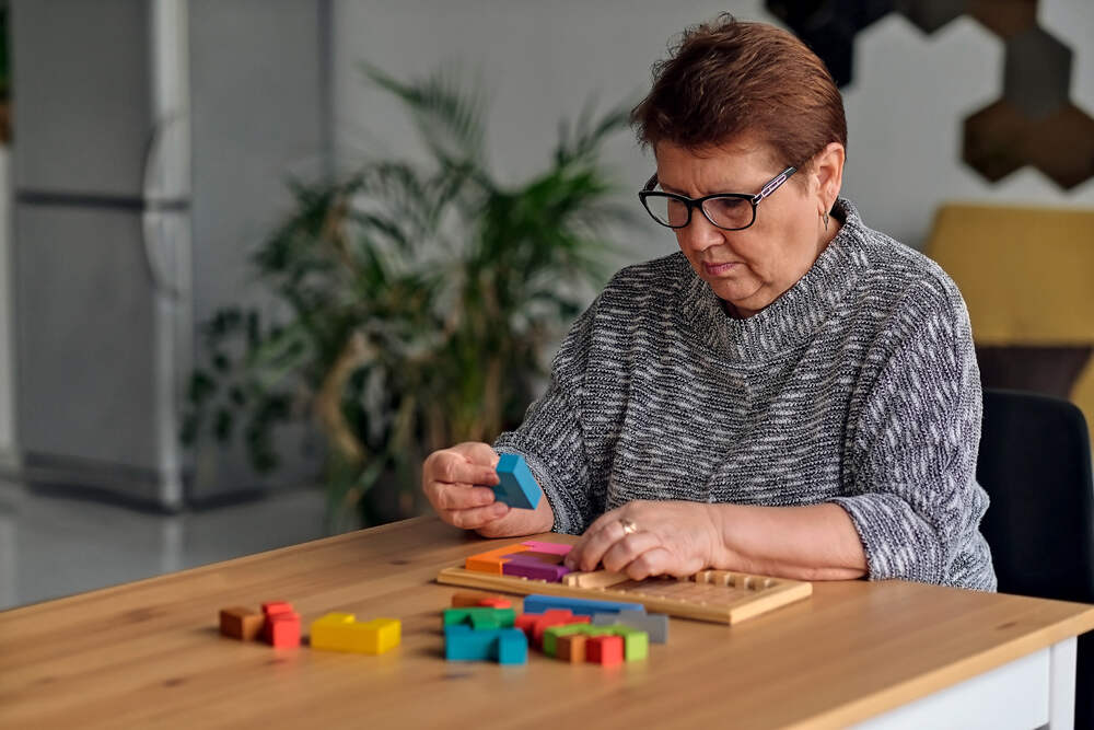 Old woman performing brain exercise Old woman performing brain exercise