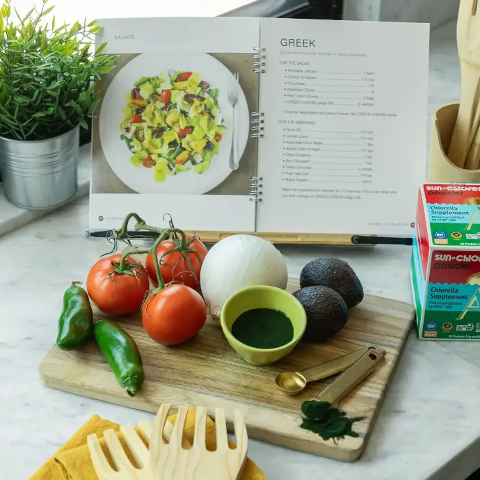 Chlorella Chef’s Bundle | Includes Sun Chlorella Powder, Recipe Book, Cutlery Set & Travel Kit Chlorella in the Kitchen cookbook opened to a recipe with the ingredients in front of it.